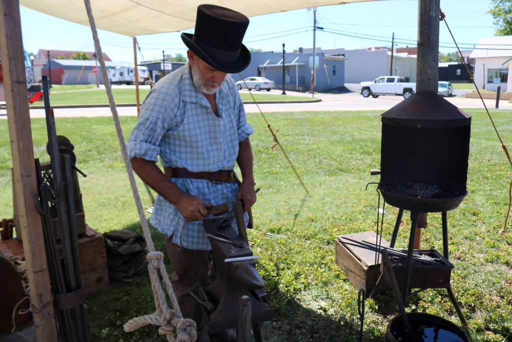 Blacksmith Station Image 5: the blacksmith is back at the anvil to work with the metal.