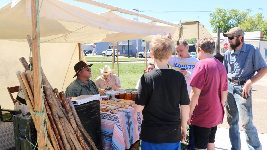 Woodcarving and Honey Exhibit Image 2: we see fellow visitors of the festival learning more about the honey and beekeeping.